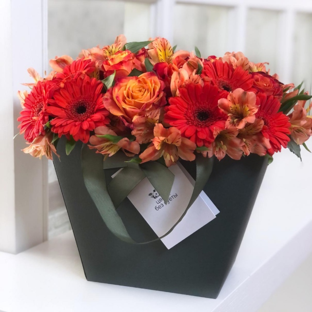 MF0670 - Зеленая фирменная сумка с оранжевыми герберами и розами фото - moscowflorist.ru