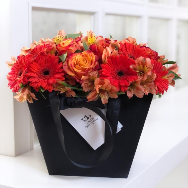MF0675 - Черная фирменная сумка с оранжевыми розами и герберами фото - moscowflorist.ru